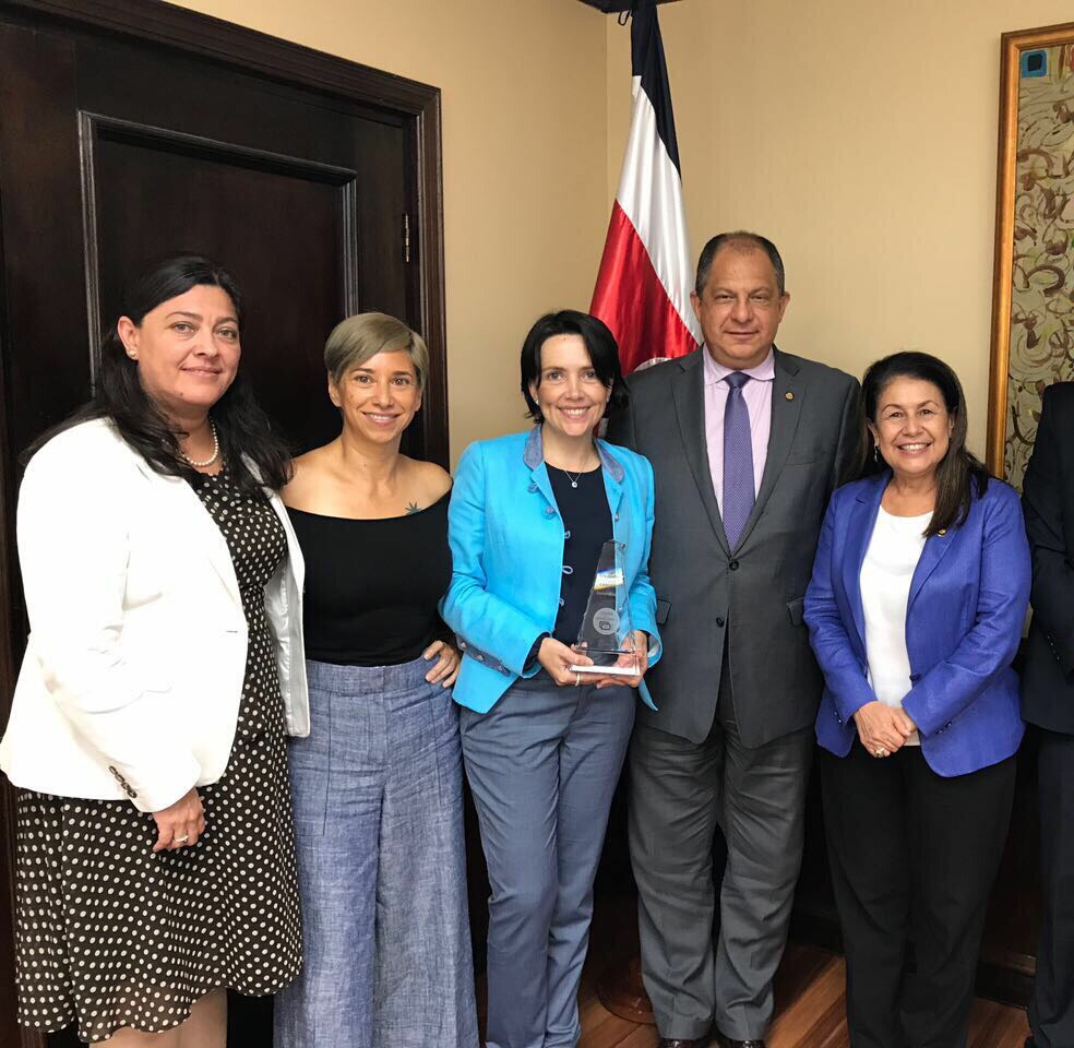 Funcionarias de la UNED recibiendo premio del expresidente de Costa Rica, Luis Guillermo Solís